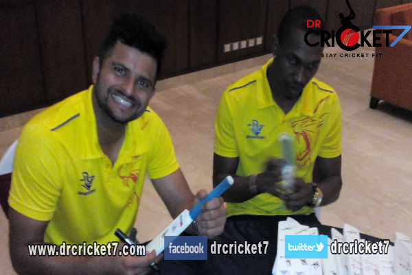Suresh Raina and Dwayne Bravo signing autographs.