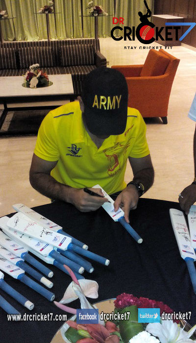 MS Dhoni signing autographs in an event.