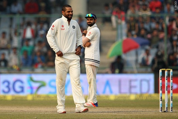 Shikhar Dhawan smiles after a catch was dropped from his bowling as Virat Kohli looks.